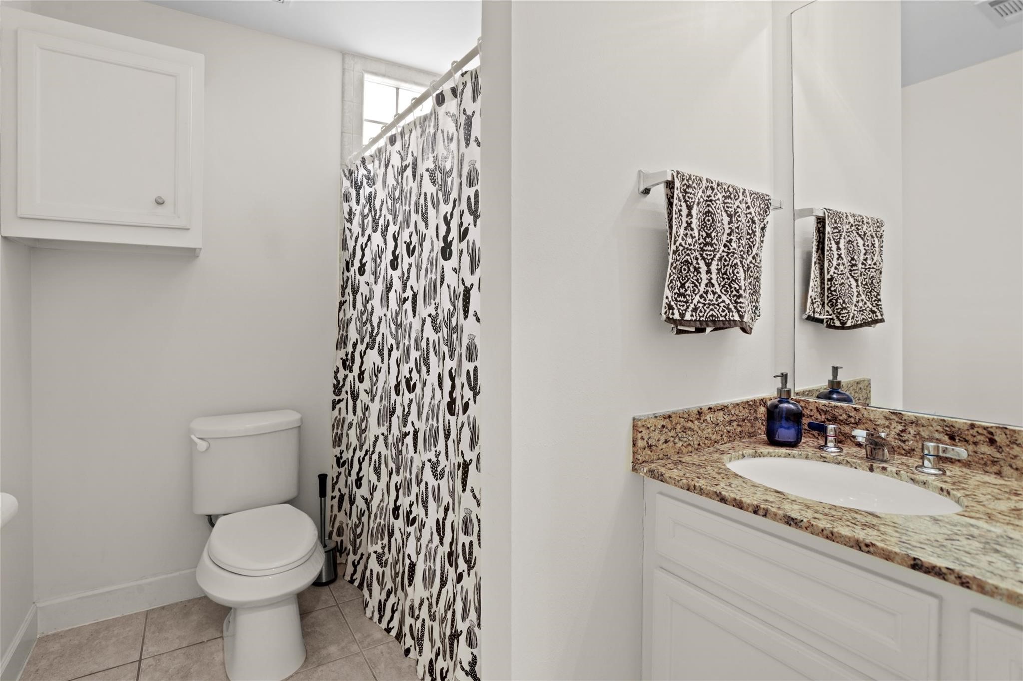 2710 Hullsmith Drive, Unit 604 Houston, TX 77063 - Photo 13 of 27 a bathroom with a granite countertop toilet a sink and a mirror