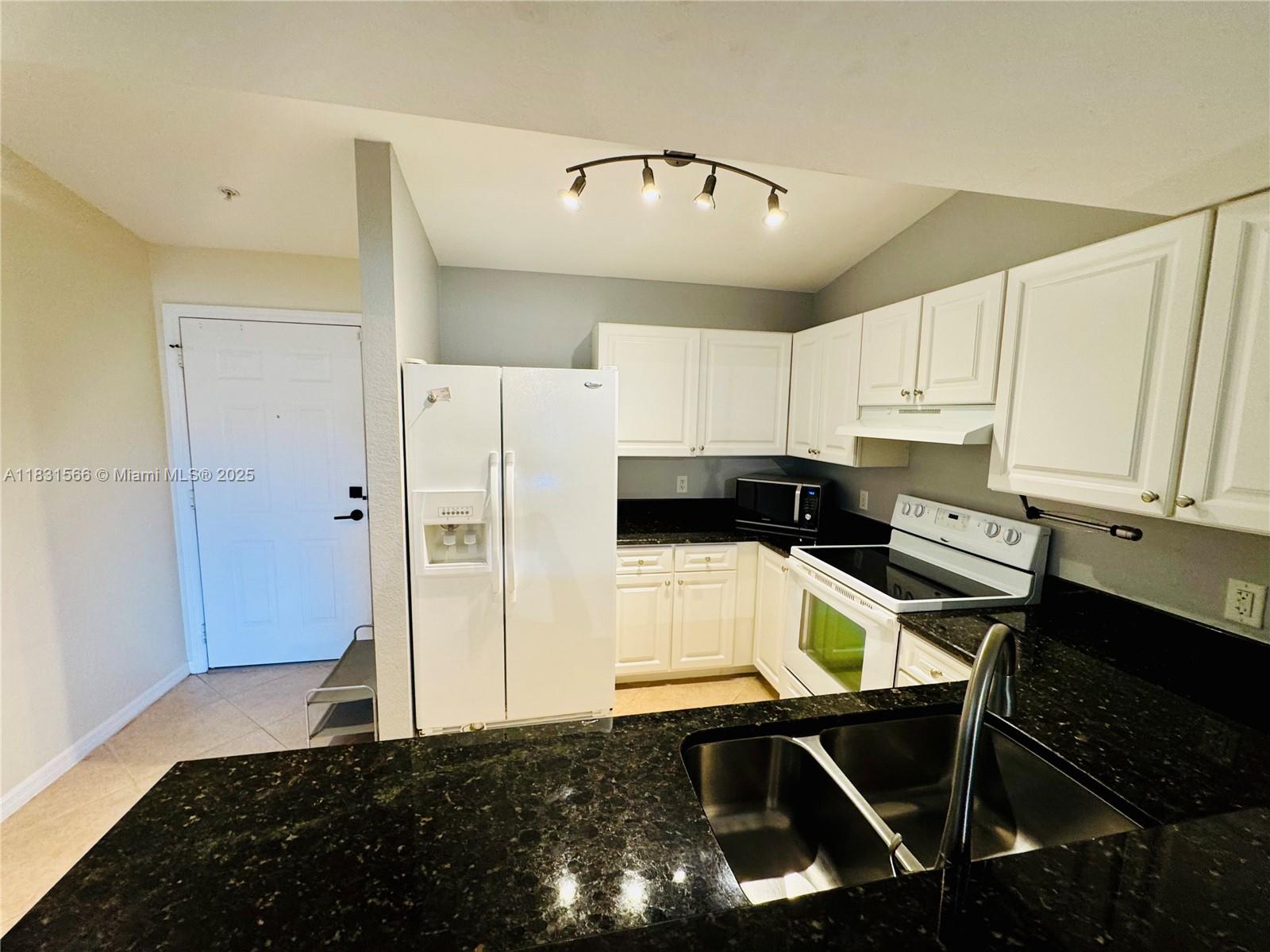 8244 Key Royal Circle, Unit 633 Naples, FL 34119 - Photo 15 of 37 a kitchen with a refrigerator and a stove top oven