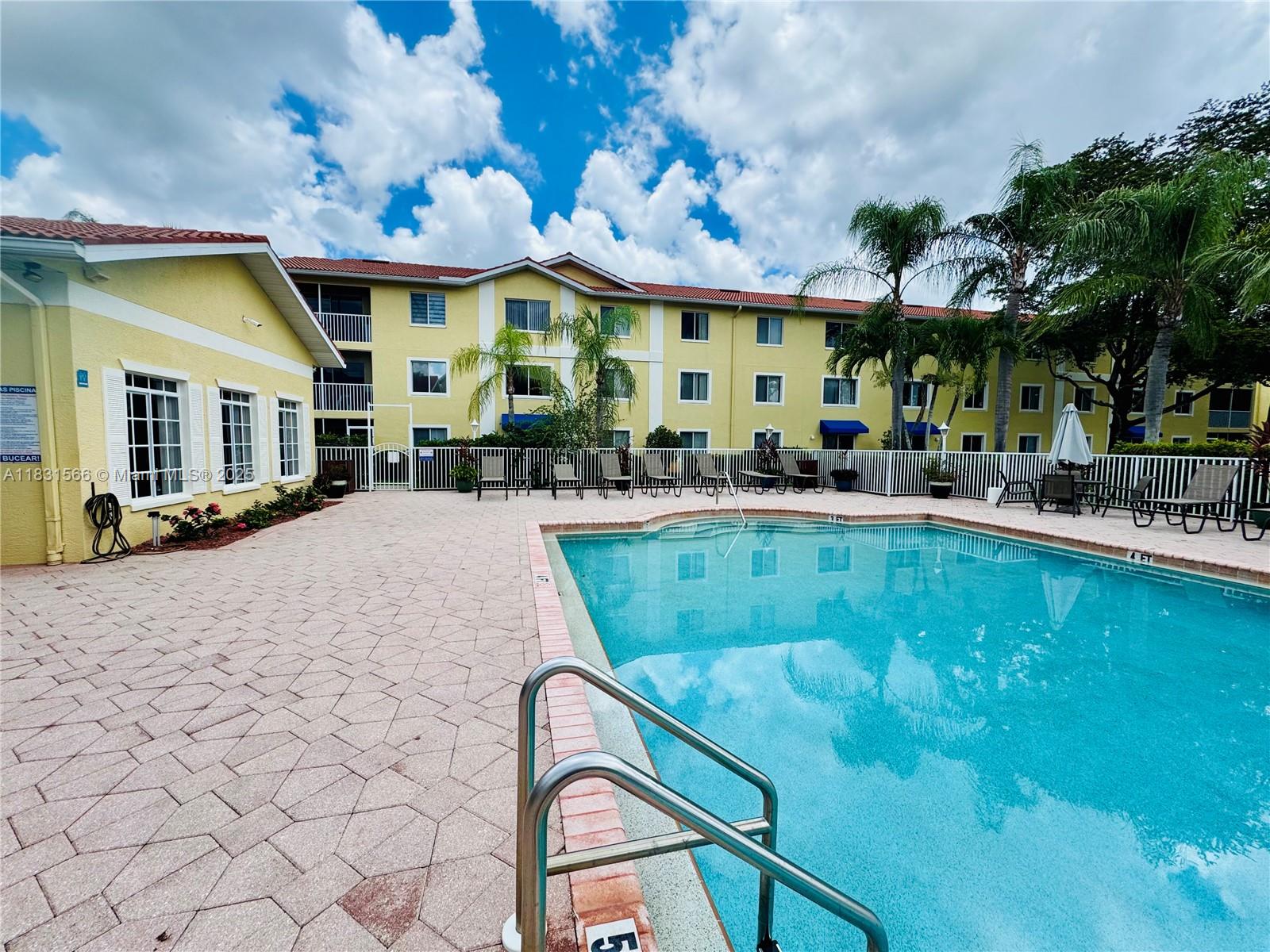 8244 Key Royal Circle, Unit 633 Naples, FL 34119 - Photo 35 of 37 a swimming pool with outdoor seating and yard