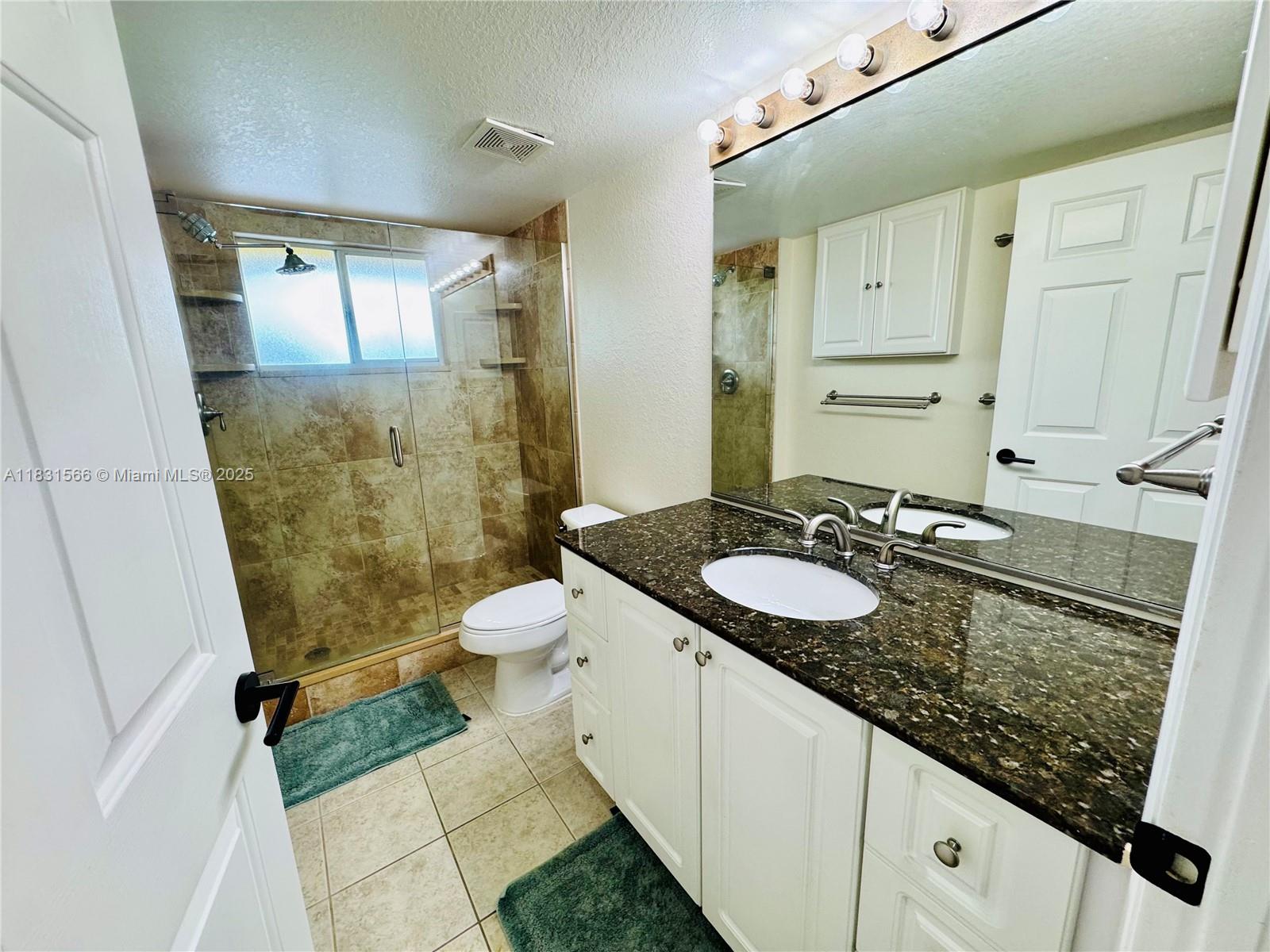 8244 Key Royal Circle, Unit 633 Naples, FL 34119 - Photo 4 of 37 a bathroom with a granite countertop sink toilet and shower