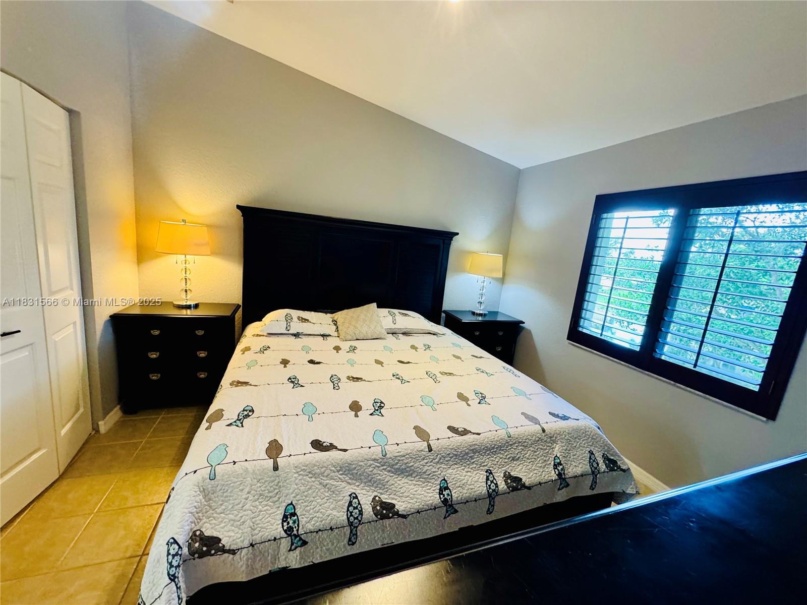 8244 Key Royal Circle, Unit 633 Naples, FL 34119 - Photo 9 of 37 a bed sitting in a bedroom next to a window