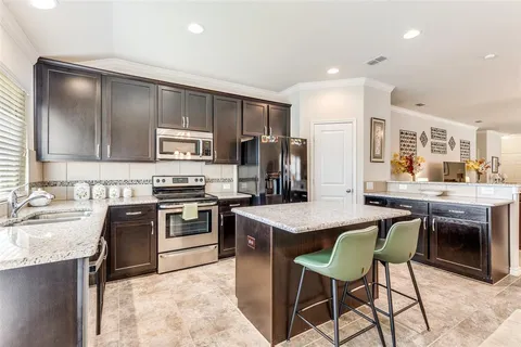 a kitchen with kitchen island a sink stove and refrigerator