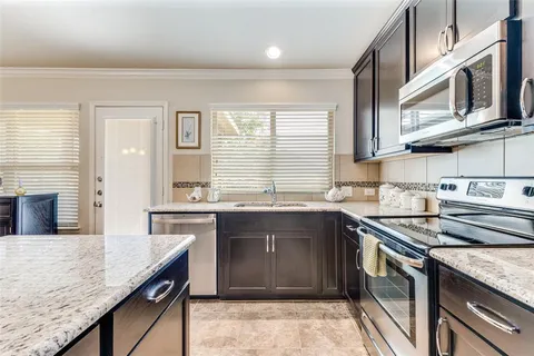 a kitchen with stainless steel appliances granite countertop a sink and stove