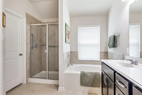 a bathroom with a tub shower and sink