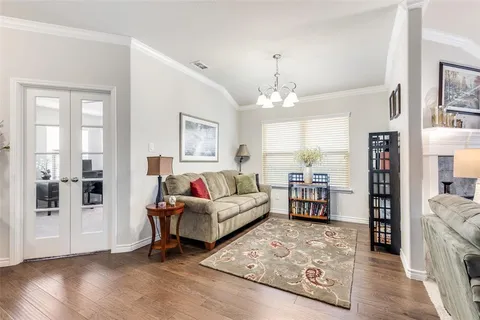 a living room with furniture and a chandelier