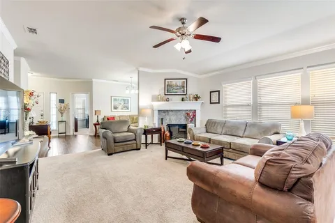 a living room with furniture a fireplace and a large window