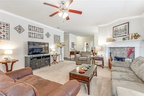 a living room with furniture a flat screen tv and a fireplace