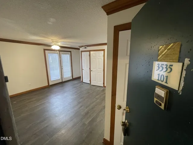an empty room with wooden floor and windows