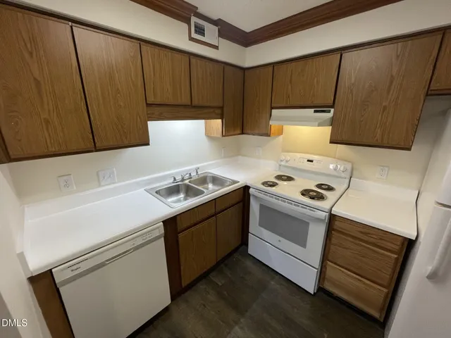 a kitchen with a stove cabinets and wooden floor