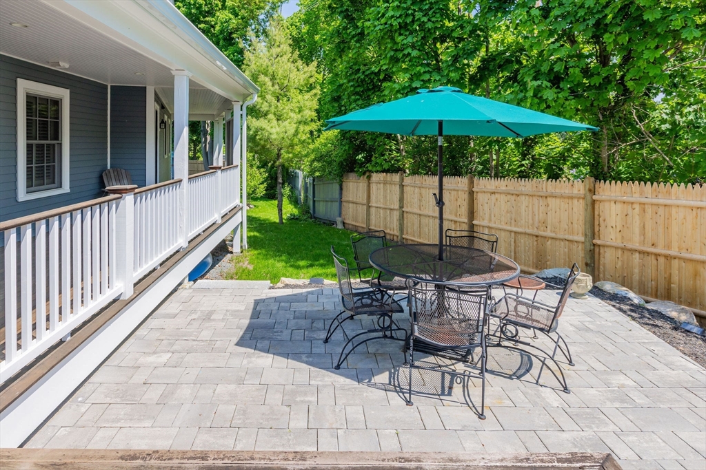 27 Maverick Street Marblehead, MA 01945 - Photo 31 of 31 a view of a table and chair under an umbrella in backyard
