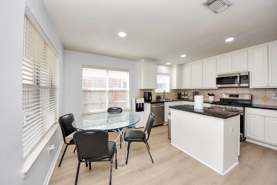 1054 Inverness Cove Dickinson, TX 77539 - Photo 12 of 28 a kitchen with a dining table chairs and a microwave