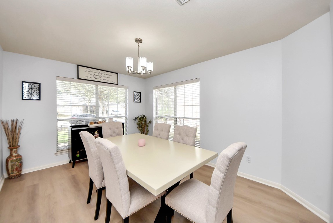 1054 Inverness Cove Dickinson, TX 77539 - Photo 7 of 28 a view of a dining room with furniture a chandelier and wooden floor