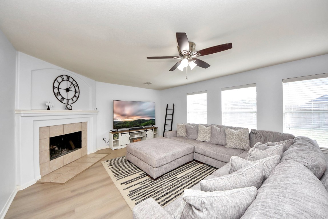 1054 Inverness Cove Dickinson, TX 77539 - Photo 9 of 28 a living room with furniture a fireplace and a flat screen tv