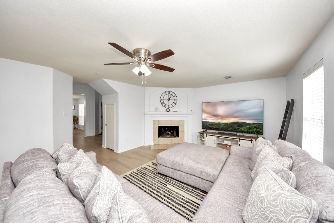 1054 Inverness Cove Dickinson, TX 77539 - Photo 10 of 28 a living room with furniture a fireplace and a flat screen tv