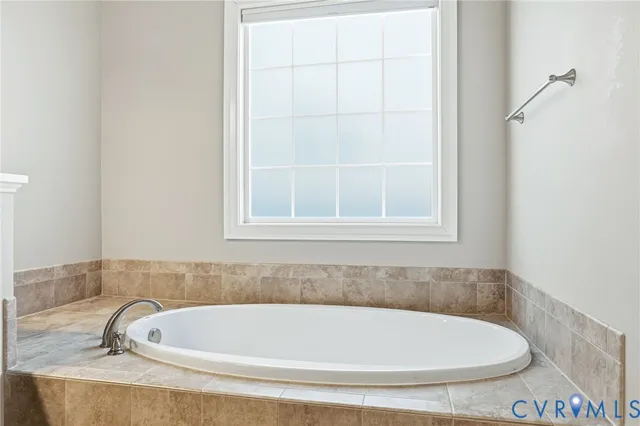 an empty room with windows and chandelier fan