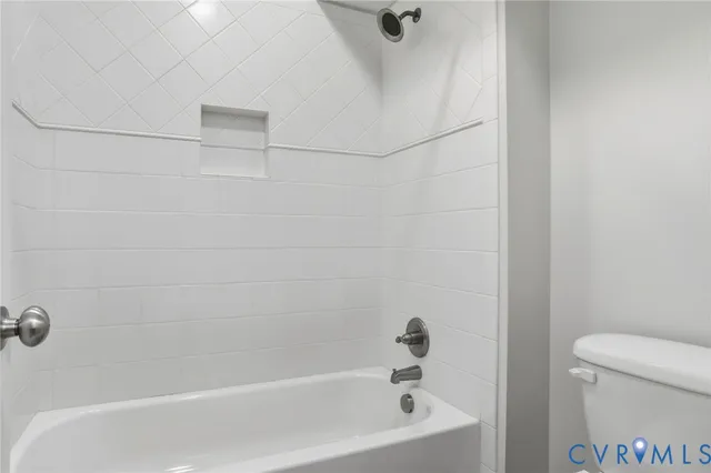 a front view of a building with a garden and trees