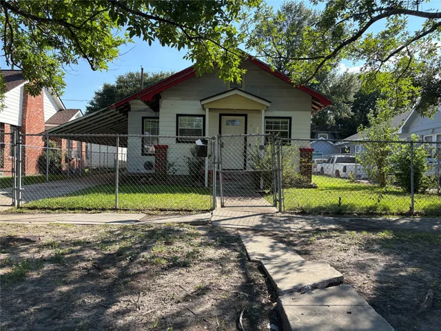 a view of a house with a backyard and a tree