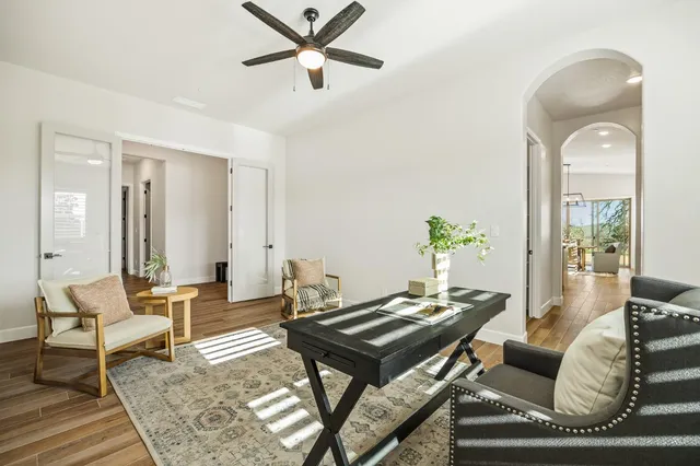 a view of a hallway with wooden floor and a bathroom