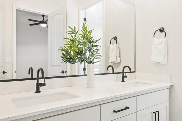 a bathroom with a sink a mirror a toilet and shower