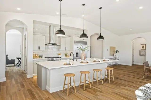 a kitchen with kitchen island a counter top space a sink appliances and cabinets