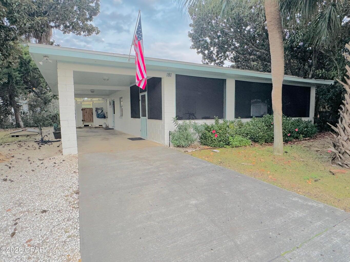 front view of a house with a yard and potted plants