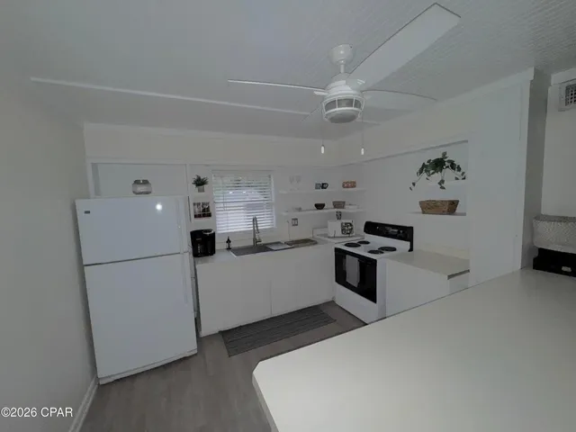 a kitchen with a refrigerator and a stove top oven
