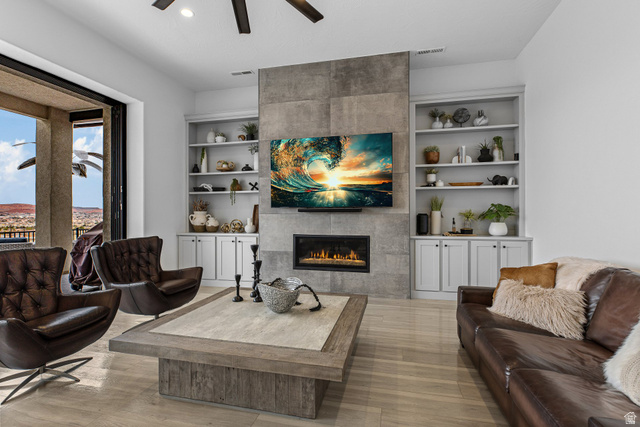 3022 West Sesia Way St. George, UT 84770 - Photo 47 of 52 Living room with a tiled fireplace, a ceiling fan, and built in features