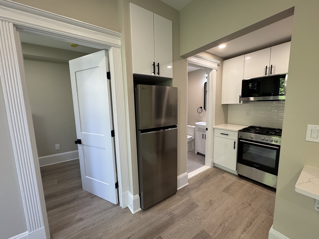 41 Edgerly Road, Unit 28 Boston, MA 02115 - Photo 6 of 13 a kitchen with stainless steel appliances a refrigerator a sink and white cabinets