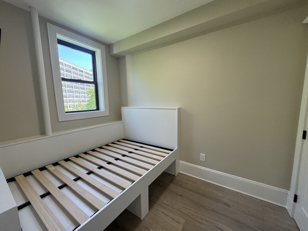 41 Edgerly Road, Unit 28 Boston, MA 02115 - Photo 8 of 13 a view of an empty room with wooden floor and a window