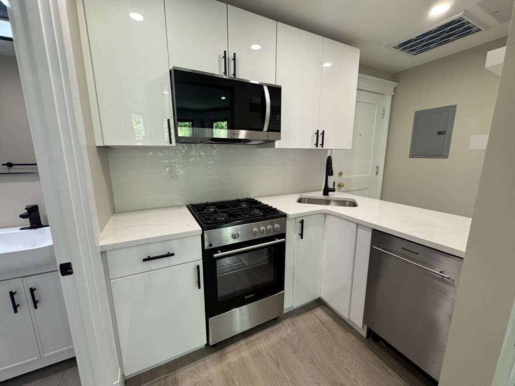 41 Edgerly Road, Unit 28 Boston, MA 02115 - Photo 9 of 13 a kitchen with a stove and a microwave