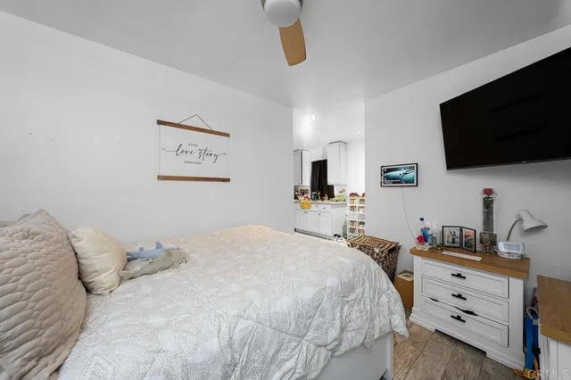 a bedroom with a bed a flat screen tv and dresser