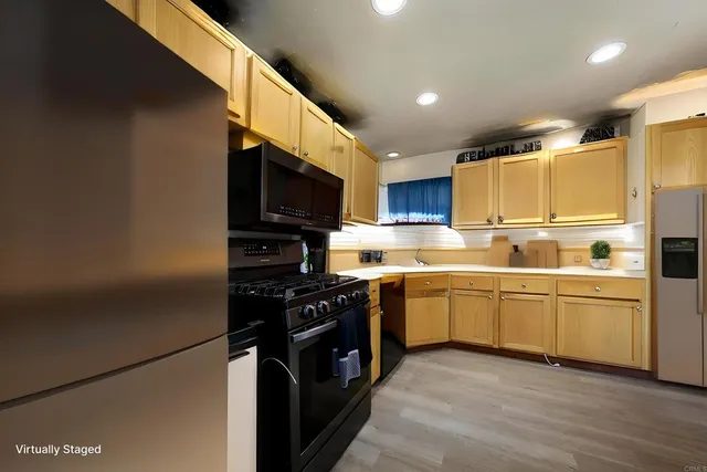 a kitchen with stainless steel appliances granite countertop a refrigerator a stove top oven a sink and dishwasher