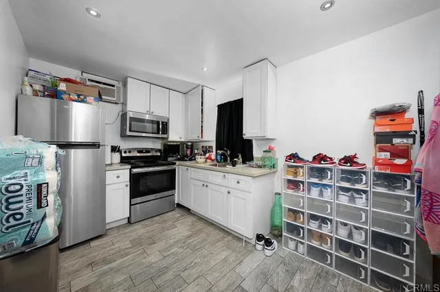 a kitchen with stainless steel appliances a stove a sink cabinets and a refrigerator