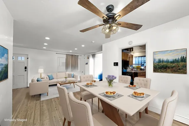a living room with furniture kitchen view and a large mirror