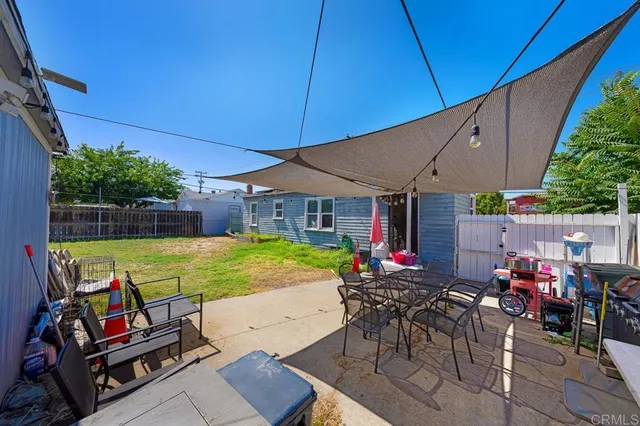 a view of a patio with table and chairs under an umbrella