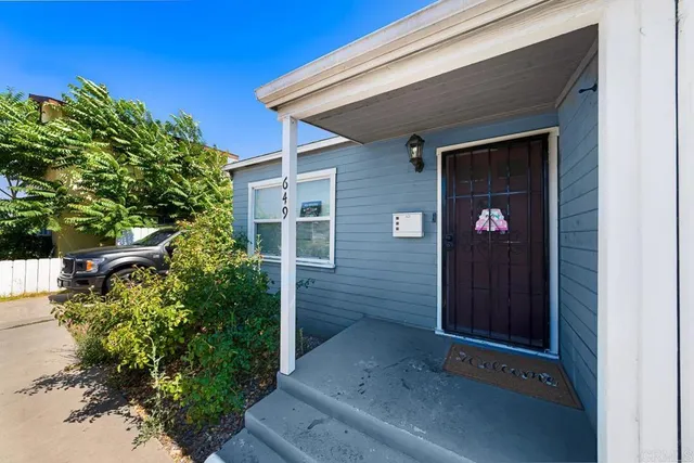 a front view of a house with a tree