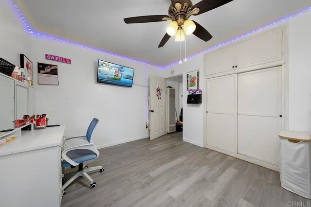 a view of a workspace with furniture and a ceiling fan