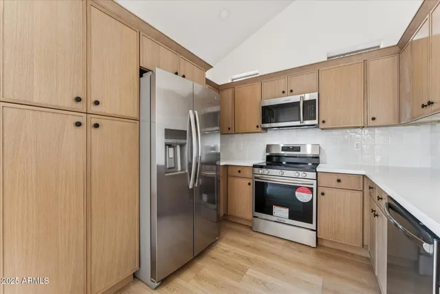 a kitchen with stainless steel appliances a refrigerator sink and microwave