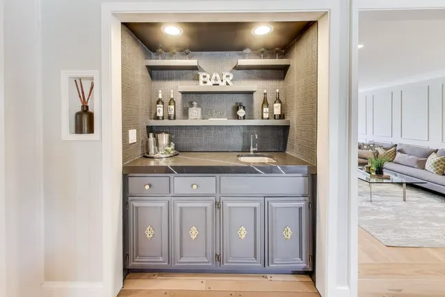a kitchen with a sink and a stove with wooden floor
