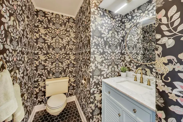 a bathroom with a granite countertop toilet and a sink