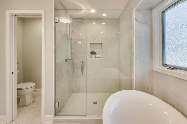 a bathroom with a toilet and a shower