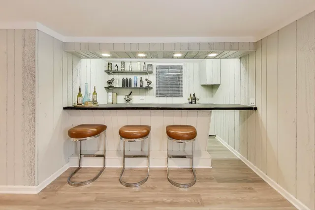 a kitchen with stainless steel appliances kitchen island granite countertop a table chairs in it and wooden floor