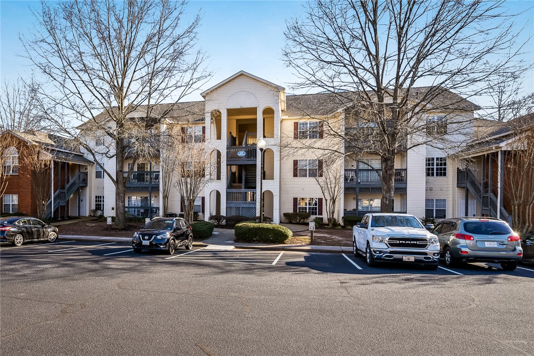 This multi-level apartment complex features charming balconies and convenient parking, ideal for comfortable living.