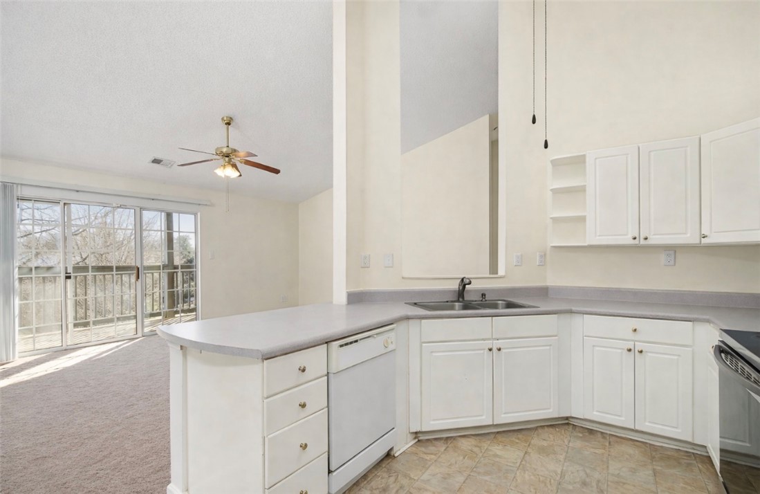 151 Wexford Drive, Unit 301 Anderson, SC 29621 - Photo 12 of 29 This bright kitchen features ample cabinetry and flows into a carpeted living space with a sliding door.