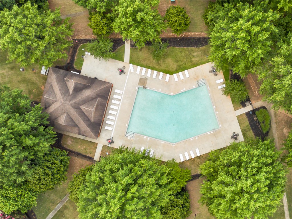 151 Wexford Drive, Unit 301 Anderson, SC 29621 - Photo 7 of 29 An aerial view captures a refreshing pool surrounded by vibrant greenery and a shaded pavilion.