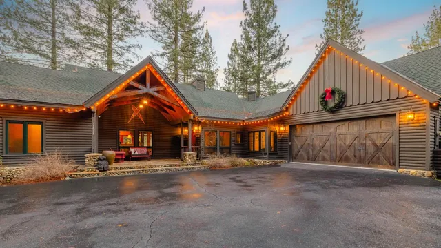 a view of a house with large windows and a wooden fence