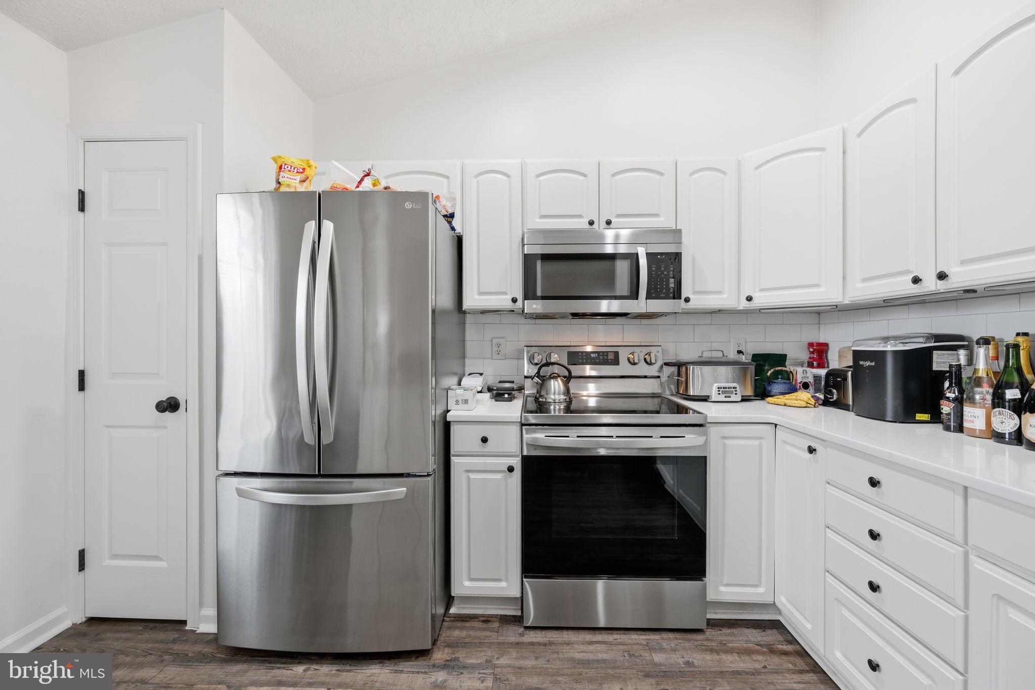 695 Winding Stream Way, Unit 301 Odenton, MD 21113 - Photo 4 of 25 a kitchen with stainless steel appliances a refrigerator stove and white cabinets