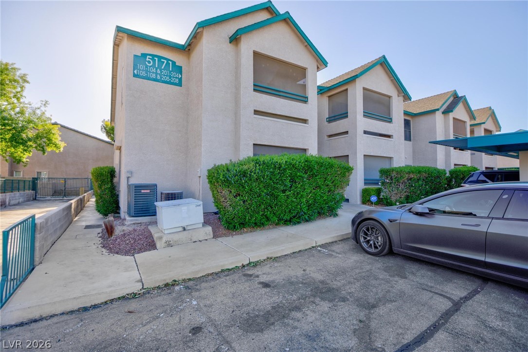 5171 South Lindell Road, Unit 103 Las Vegas, NV 89118 - Photo 2 of 24 A cream-colored stucco building with teal trim offers multiple units with individual entrances.