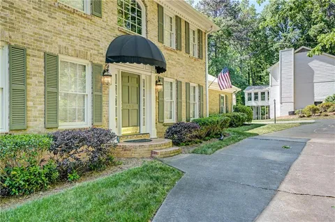 a kitchen with stainless steel appliances granite countertop a stove a sink a dining table and chairs with wooden floor