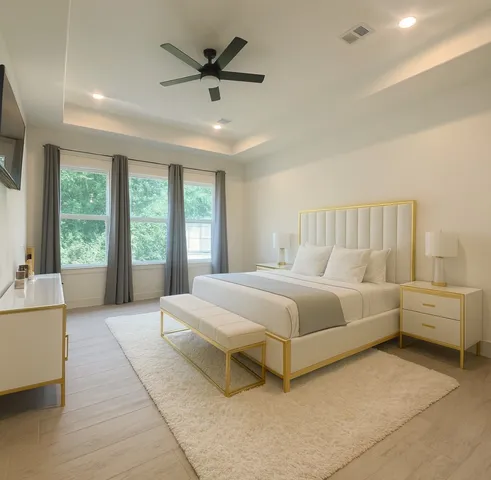a spacious bedroom with a large bed and a chandelier